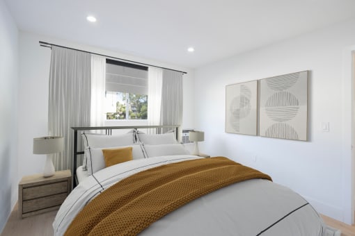 a white bedroom with a bed and a window
