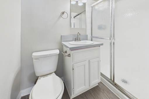A white toilet sits next to a sink in a small bathroom.