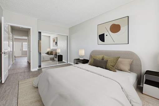 A bedroom with a large bed and a painting on the wall.