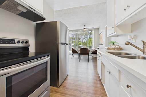 A modern kitchen with a black stove top oven and a white refrigerator.