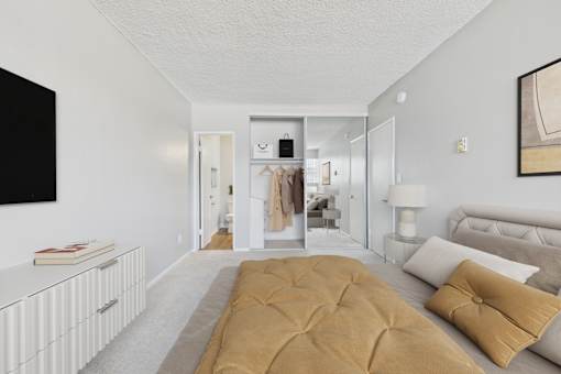 A bedroom with a large bed and a wardrobe in the background.
