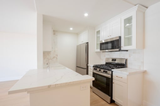 a kitchen with white cabinets and a stove and a refrigerator