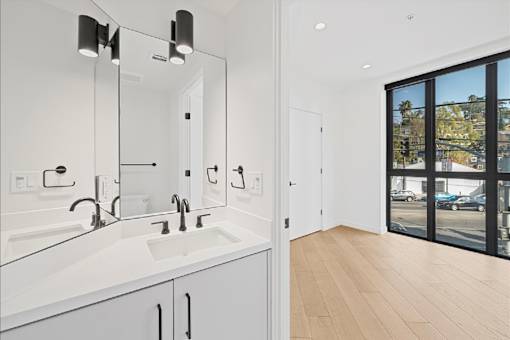 A bathroom with a white sink and mirror.