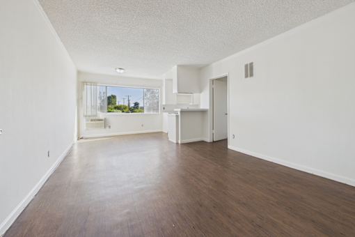 Empty room with white walls and wooden floor.