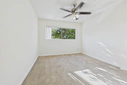 A room with a ceiling fan and a window.