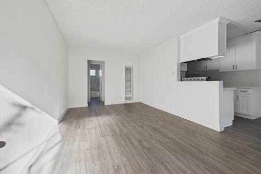 A kitchen with white cabinets and a wooden floor.