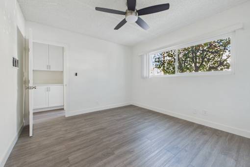 A room with a ceiling fan and a window.