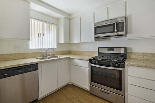 A kitchen with a stove, oven, dishwasher, and microwave.