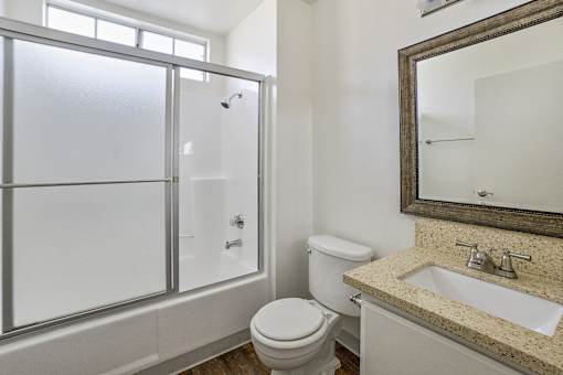 A bathroom with a toilet, sink, and shower.