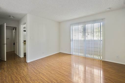 A room with wooden floors and a sliding glass door.