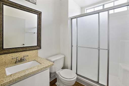 A bathroom with a toilet, sink, and shower.