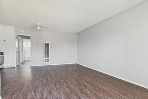 A room with wooden flooring and white walls.