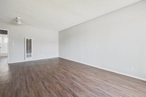 A room with wooden flooring and a ceiling fan.
