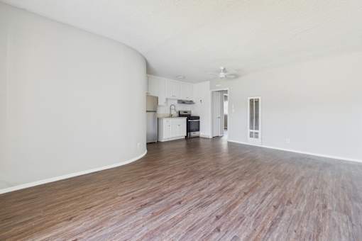 A room with wooden flooring and white walls.