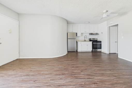A kitchen with white cabinets and a stainless steel refrigerator.