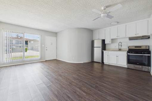 A kitchen with white cabinets and a refrigerator.
