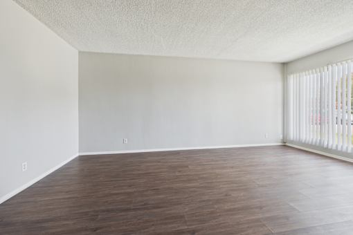 A room with wooden flooring and white walls.