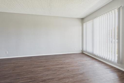 A room with wooden flooring and white walls.