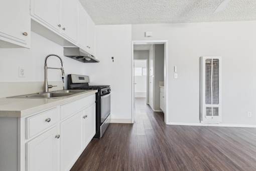 A kitchen with white cabinets and a black stove top oven.