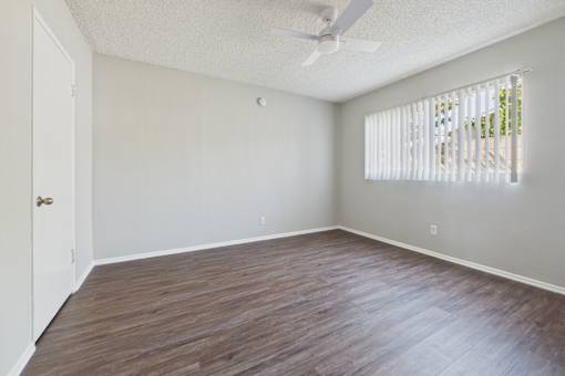 A room with a wooden floor and a ceiling fan.