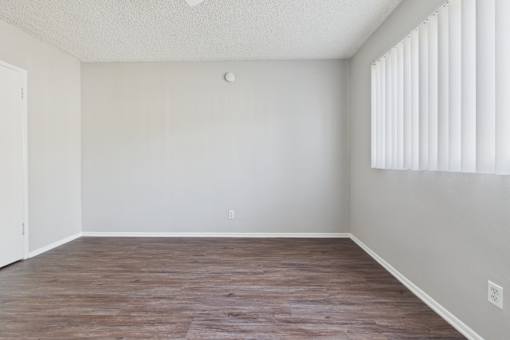 A room with wooden flooring and white walls.
