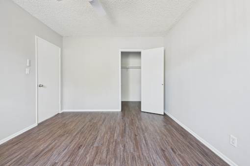 A room with a wooden floor and two white doors.