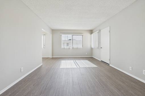A room with light wood flooring and white walls.