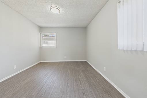 A room with a window and a wooden floor.
