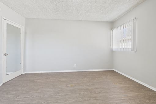 A room with a door and a window with blinds.