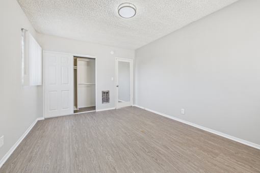 A room with a light brown floor and white walls.