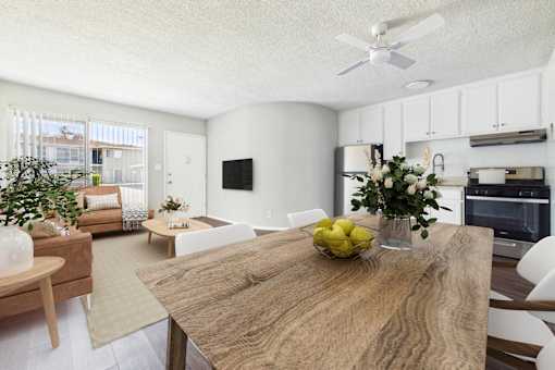 A modern kitchen with a wooden table and white chairs.