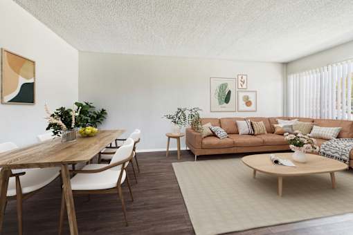A living room with a brown wooden table and white chairs.