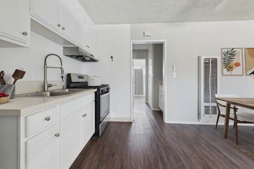 A kitchen with white cabinets and a black stove top oven.
