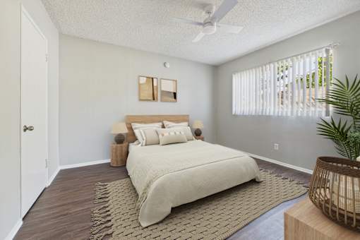 A bedroom with a large bed and a ceiling fan.