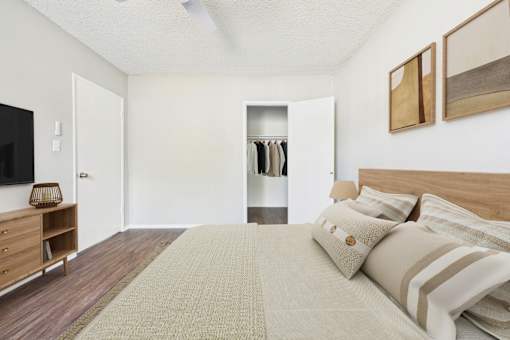 A bedroom with a large bed and a wooden dresser.