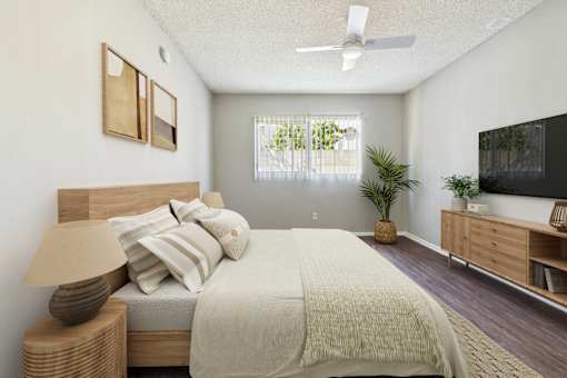 A bedroom with a bed, nightstand, and a ceiling fan.