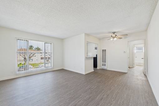 Empty room with a ceiling fan and sliding glass doors.