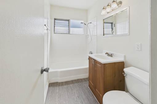A white bathroom with a toilet, sink, and bathtub.