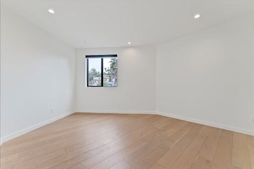 Empty room with wooden floor and a window.