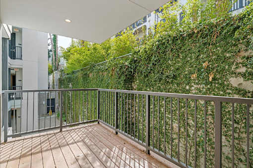A balcony with a metal railing and wooden floor.