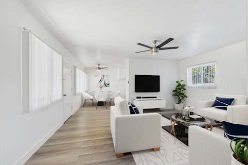 A living room with a white couch and a television.