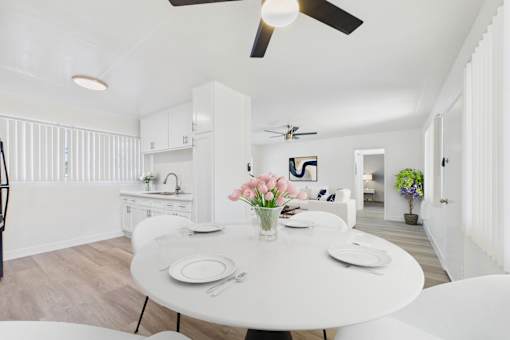 A dining room with a white table and chairs.