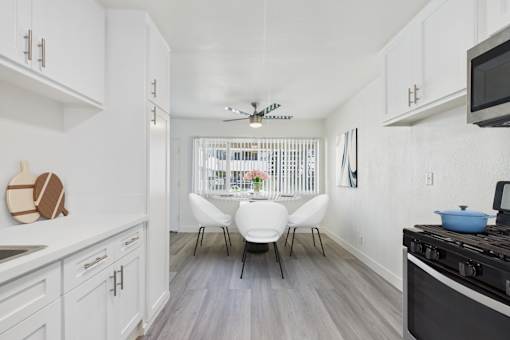 A kitchen with white cabinets and a black stove top.