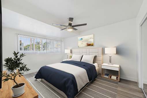 A bedroom with a bed, nightstand, and a ceiling fan.