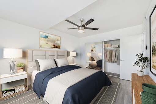 A bedroom with a large bed and a ceiling fan.