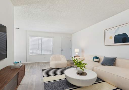 A living room with a white couch, a round coffee table, and a painting on the wall.