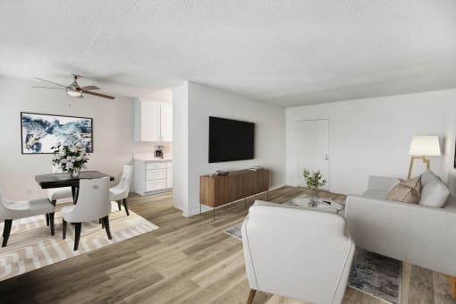 a living room and dining room with white furniture and a tv