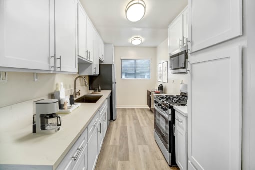 a white kitchen with a stove and a sink