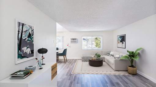 A living room with a couch, chair, and potted plant.