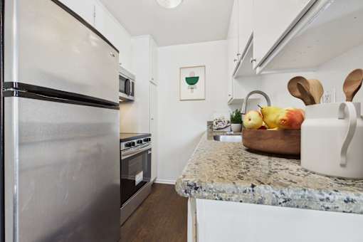 A kitchen with a granite countertop and a refrigerator.